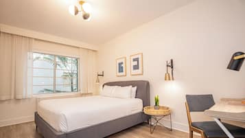 Una habitación de hotel moderna con una cama grande, un escritorio y una silla.