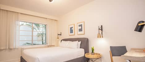 Une chambre d’hôtel moderne, dotée d’un grand lit, d’un bureau et d’une chaise.