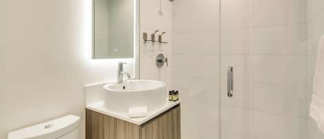 Une salle de bain moderne avec un lavabo, un miroir et une douche.