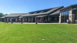 A building with a covered patio area, outdoor seating, and a well-maintained lawn. - Lake Arrowhead Retreat with club pools and beaches (Nekoosa)