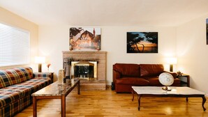 Ein Wohnzimmer mit Kamin, einer Couch, einem Sofa und einem Couchtisch.
