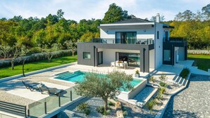 A modern two-story house with a swimming pool, outdoor seating, and a well-maintained garden. - Stunning home in Barban (Barban)