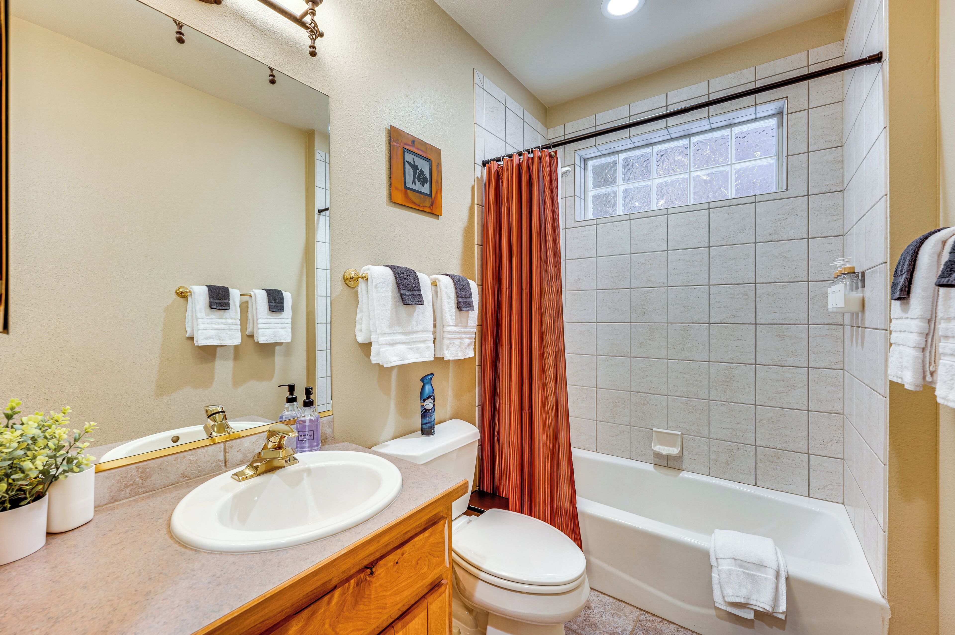 A bathroom with two sinks, a toilet, a bathtub, and a shower curtain.