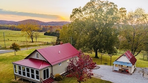 A two-story house with a red roof, a large tree in front, and a small shed to the right. - 4K Ranch - 10 acre property & home near Hermann (New Florence)