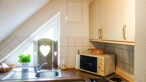 A kitchen with a sink, a microwave, and a stove. - Gorgeous apartment in Otterndorf (Otterndorf)