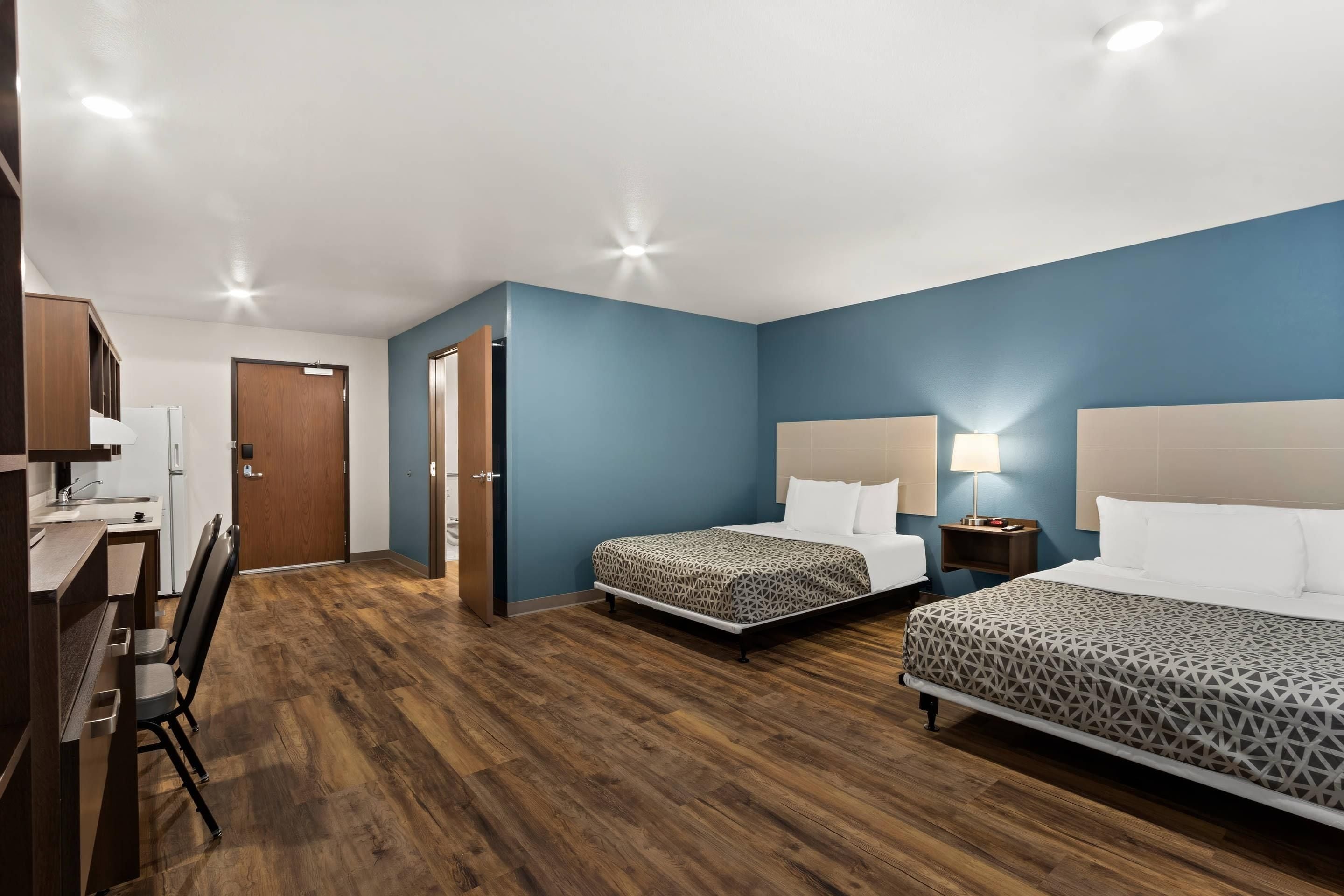 Una habitació d'hotel amb dos llits, una taula de treball i una cadira.