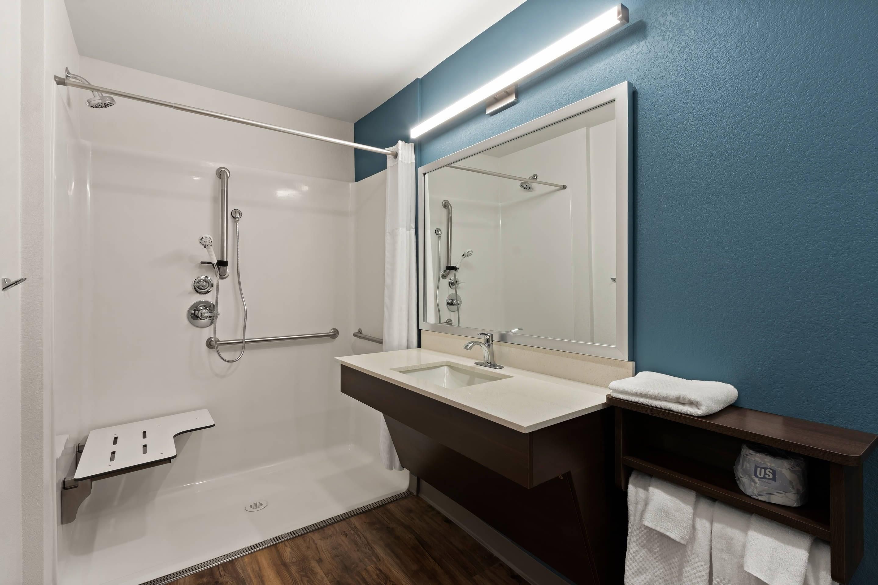 Un baño con bañera, ducha, lavamanos y espejo.