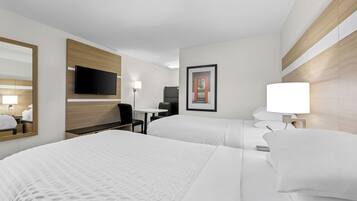 A hotel room with two beds, a flat-screen TV, a desk, and a chair.