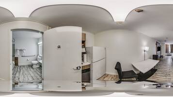 A modern interior with a white color scheme, a kitchen area, a dining space, and a bathroom with a herringbone floor pattern.