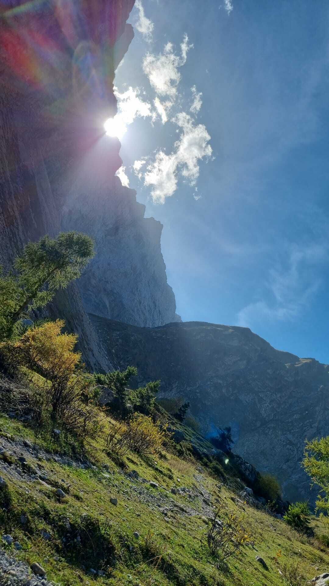 A mountainous landscape with a prominent cliff and a clear sky.