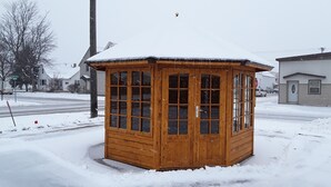 Una cabina telefónica de madera en un paisaje nevado.
