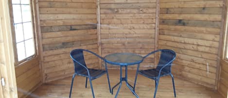 A wooden cabin with a round table and two chairs.