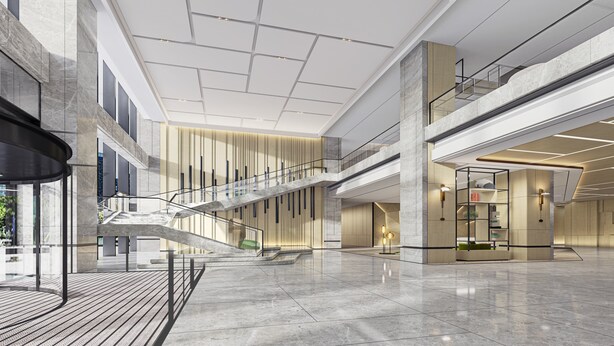 Eine großzügige Lobby mit einer zentralen Treppe, Marmorböden und modernem Design mit Holzakzenten.