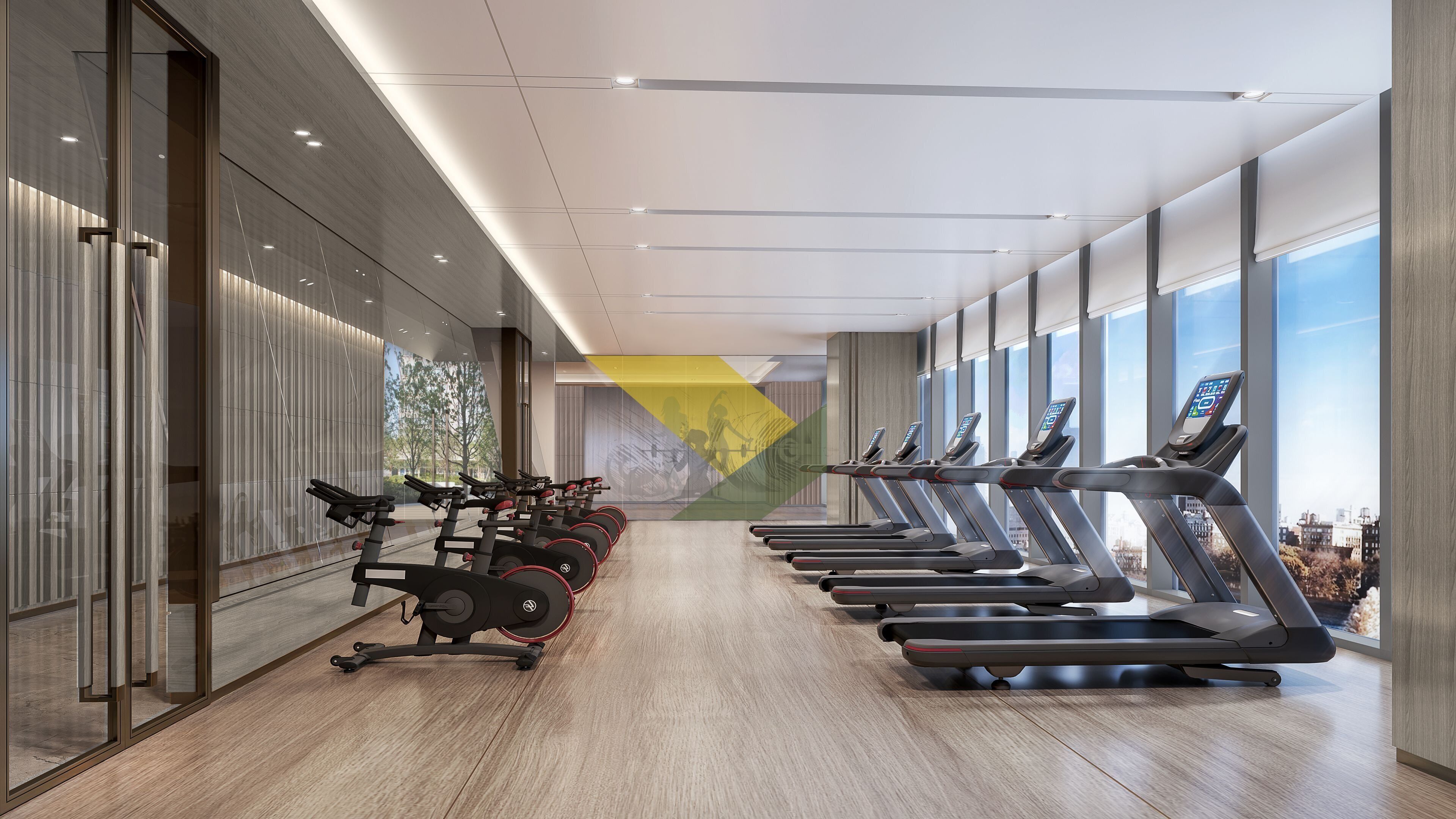 Une salle de sport dotée de nombreux tapis de course disposés en rangées, de grandes fenêtres et d’un aménagement intérieur moderne.