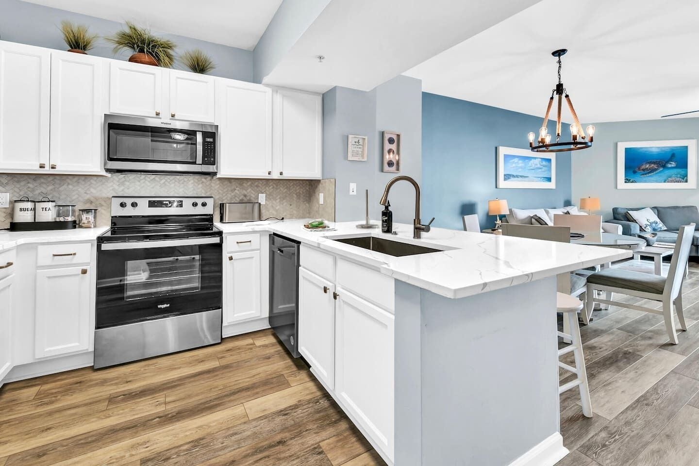 A modern kitchen with white cabinetry, a built-in oven, and a microwave.