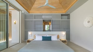Ein modernes Schlafzimmer mit einem großen Bett, Holzboden und Blick durch ein Fenster.