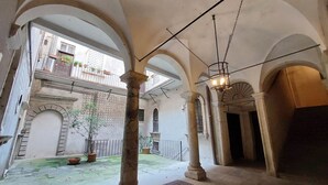 An interior courtyard with arches, columns, and a view of the outside building.