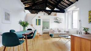 A modern interior with a dining area, a sofa, and a small table.