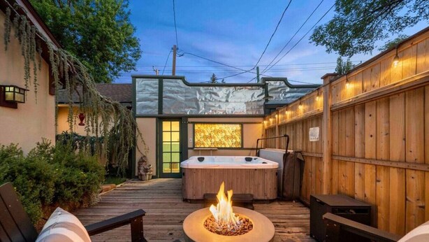 A backyard with a hot tub, a fire pit, and wooden deck seating. - Quaint Heart of Downtown Flagstaff Unit w/Spa & AC (Flagstaff)