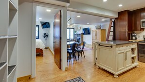 A spacious kitchen with wooden cabinets, a central island, and a dining area with chairs. - Copper Mtn Condo w/ Heated Pool: Ski-In/Walk-Out! (Frisco)