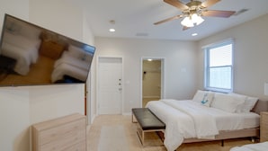 A bedroom with a bed, a bench, a dresser, a ceiling fan, and a TV mounted on the wall. - Lakefront Jackson Vacation Rental w/ Shared Yard (Jackson)