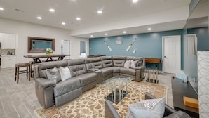A spacious living area with a large L-shaped gray sectional sofa, a glass coffee table, and a patterned rug. - Lakefront Jackson Vacation Rental w/ Shared Yard (Jackson)