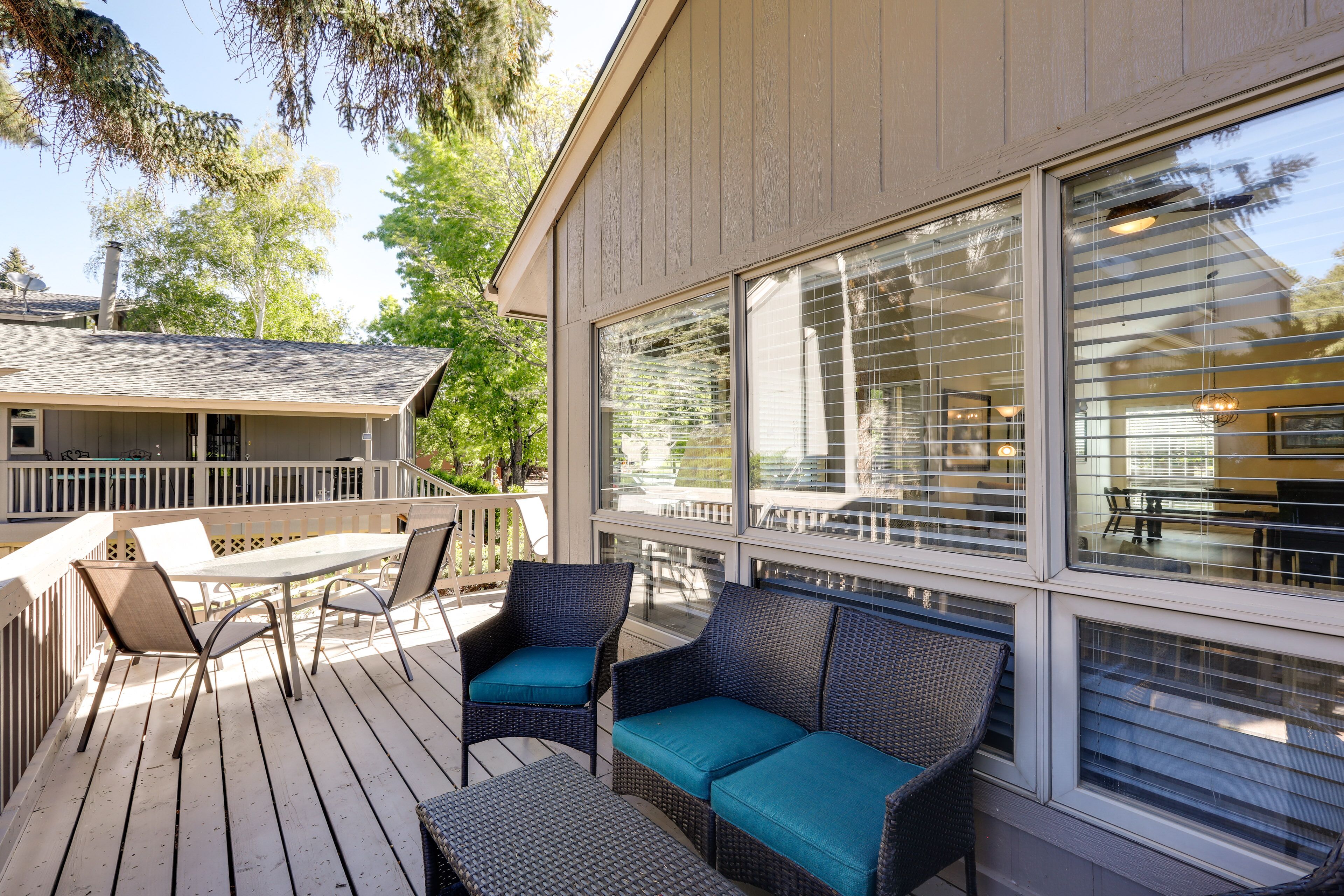 A covered outdoor deck with wicker furniture, a table, and chairs.