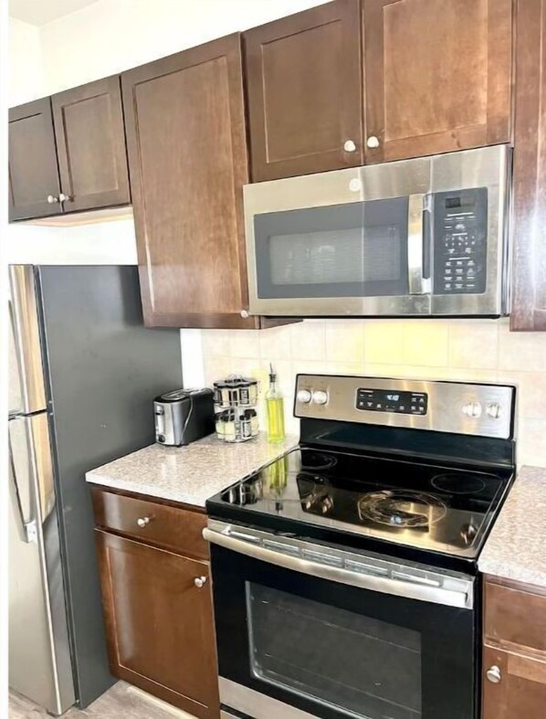 Enjoy cooking in this well-equipped kitchen with a microwave, oven, toaster, and refrigerator.