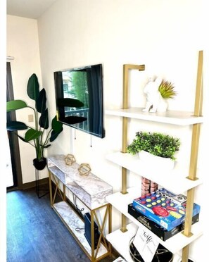 Relax and unwind in this stylish space, featuring a wall-mounted TV, console table, and shelves for entertainment and storage.