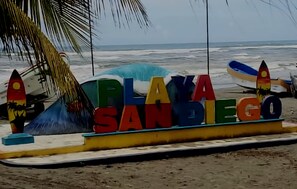 På stranden, solstolar, parasoller och surfing/bodyboarding