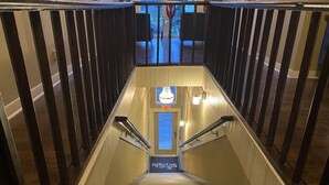 Una escalera con barandilla que lleva a una puerta con un cartel que dice 'Ski & Snow'.