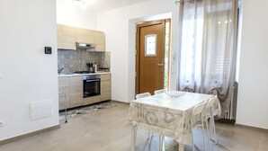 Eine moderne Küche mit hellen Holzschränken, einem eingebauten Backofen und einem Essbereich mit Tisch und Stühlen.