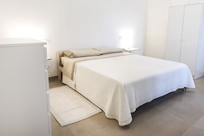 Une chambre à coucher comprenant un lit, une table de chevet, une commode et une armoire.