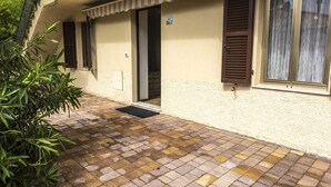 A building with a tiled patio, a door, and a window with shutters. - A28 - Poggio, large three-room apartment with porch (Poggio)