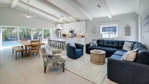 Un espacio habitable amplio con una mesa de comedor, sofás y una cocina al fondo.