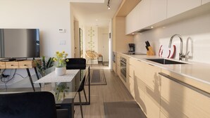 Una cocina moderna con comedor, televisor de pantalla plana y cafetera.