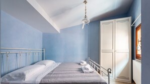 A bedroom with a bed, a wardrobe, and a hanging light fixture. - GuestHost - Apartment located on the first floor of a building, divided into two levels without a lift.In 85 square meters of space it comfortably accommodates four people with two bedrooms located on the second floor. There is an internal staircase.Loca (Venezia)