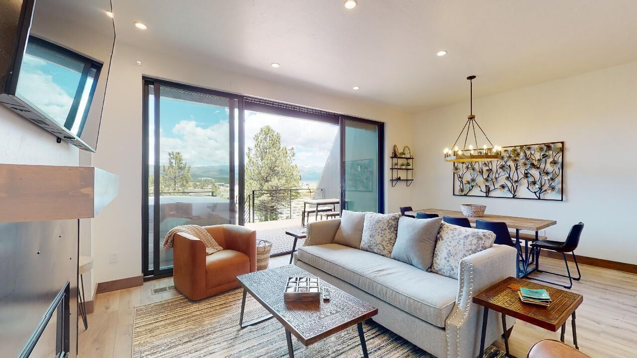 Una sala de estar moderna con un sofá, una mesa de centro y una zona de comedor con mesa y sillas.
