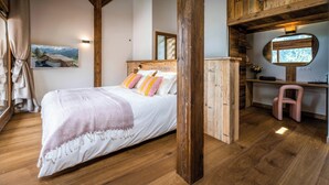 A bedroom with a wooden bed, a desk, and a chair. - Chalet Arpitania - luxury chalet for 14 with pool and spa - OVO Network (La Clusaz)