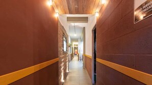 A corridor with brick walls, yellow trim, and a sign indicating a personnel-only area. - La Gruta Co-Living  (Medellín)