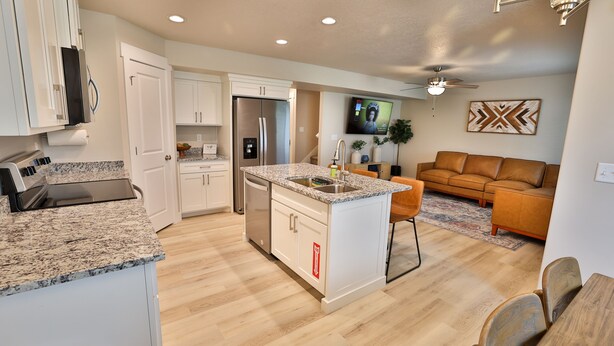 A modern kitchen with white cabinetry, granite countertops, and stainless steel appliances. - 227 - Bear Lake Escapes. Beautiful Home in an Unbeatable Location (Garden City)