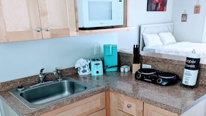 A compact kitchen with a sink, a microwave, a toaster, and a coffee maker. - Peaceful Studio Apt in Cental MB (Myrtle Beach)