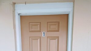 A beige door with a white frame, a keypad lock, and a number 1 sign above it. - Peaceful Studio Apt in Cental MB (Myrtle Beach)
