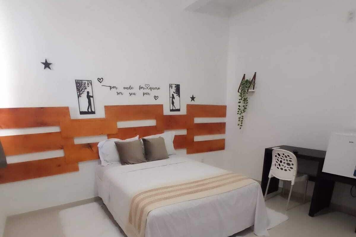 A bedroom with a bed, a desk, and a chair.