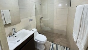 A bathroom with a sink, toilet, and shower.