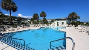 A swimming pool with lounge chairs and palm trees. - 3rd Floor Oceanfront Condo!! Community Pool & 1000 ft Fishing Pier! *Unit 308, Bldg A* (Isle Of Palms)