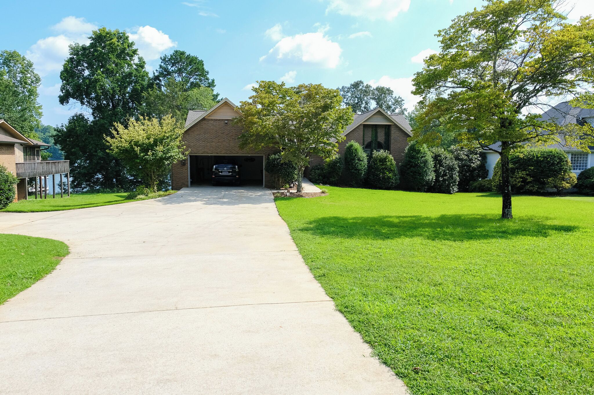 A residential driveway leading to a garage with a car parked inside.