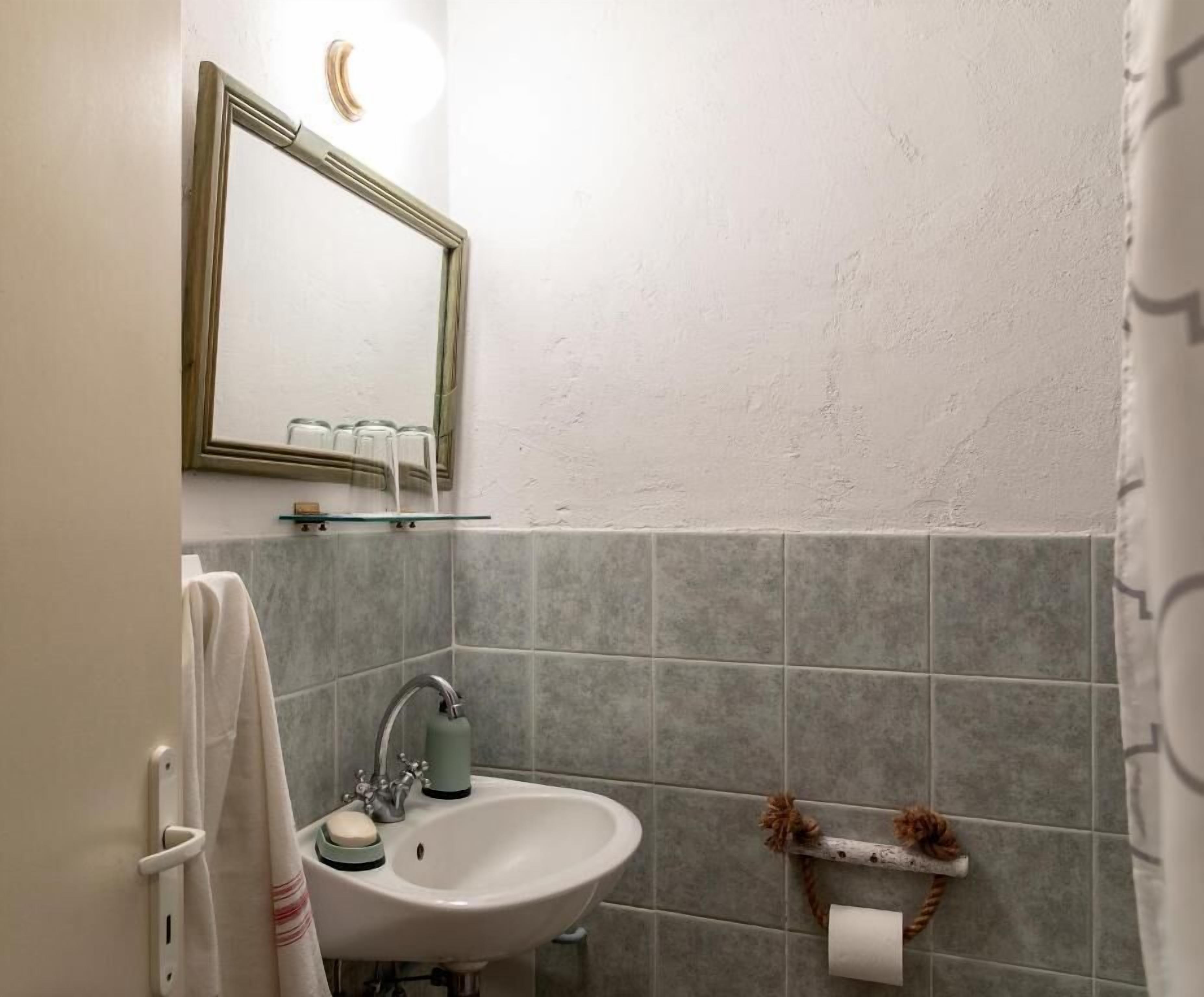 Une salle de bain équipée d’un lavabo, d’un miroir et d’un porte-serviettes.