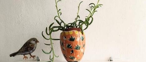 A white shelf with a ceramic pot and a plant.