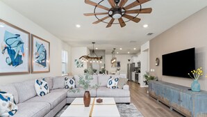 A modern living room with a sectional sofa, a coffee table, and a TV on a cabinet.